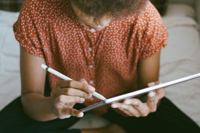 A person using a stylus on a tablet, focusing on digital drawing or writing.